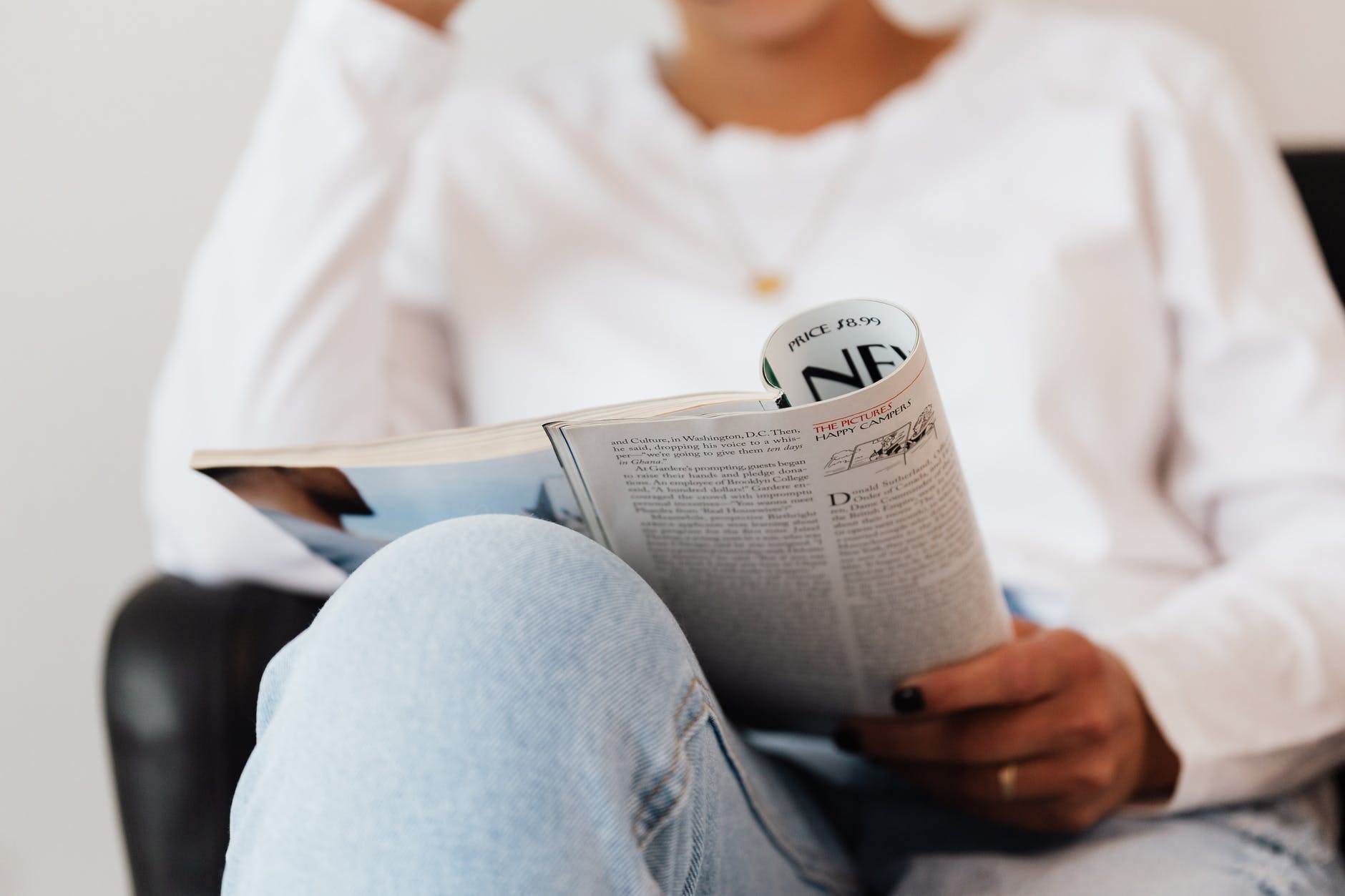 opened textbook in hand of crop anonymous woman